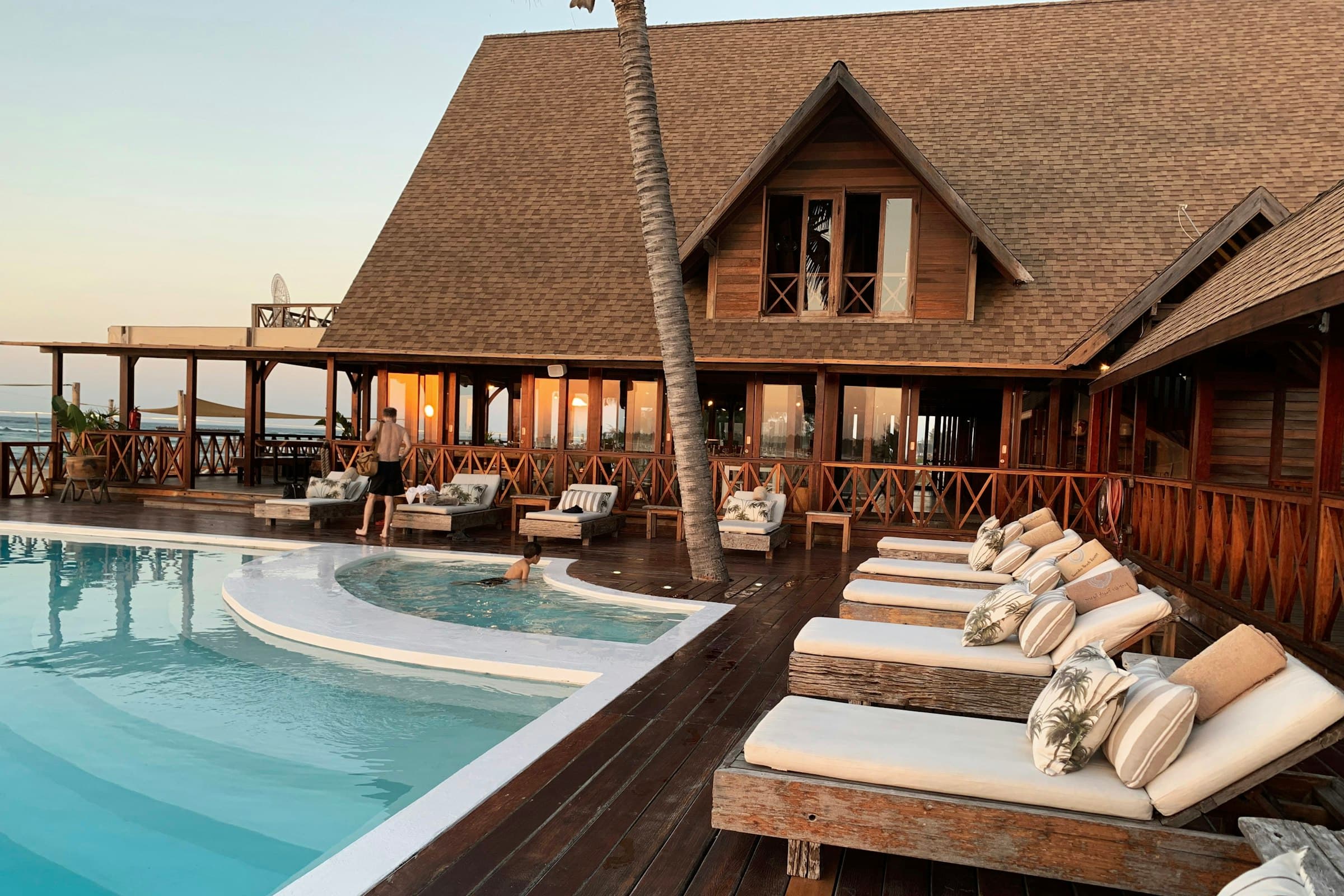 Luxury African safari lodge outdoor dining pavilion with thatched roofing and infinity deck