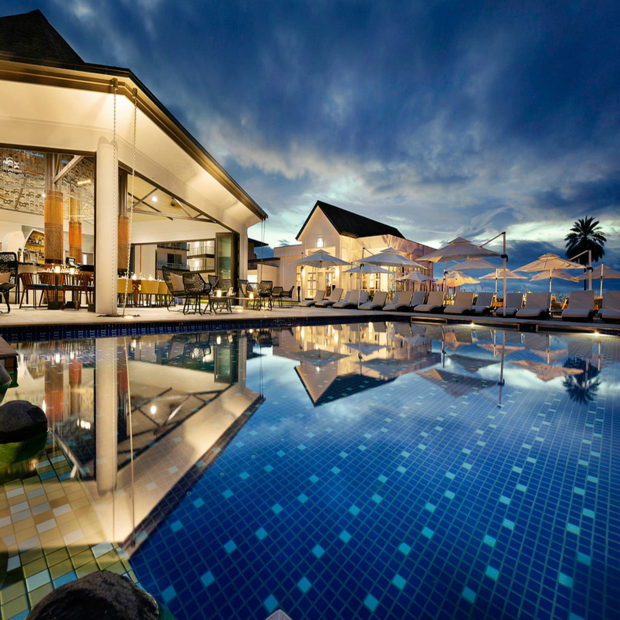 Grand luxury hotel dining courtyard illuminated at dusk