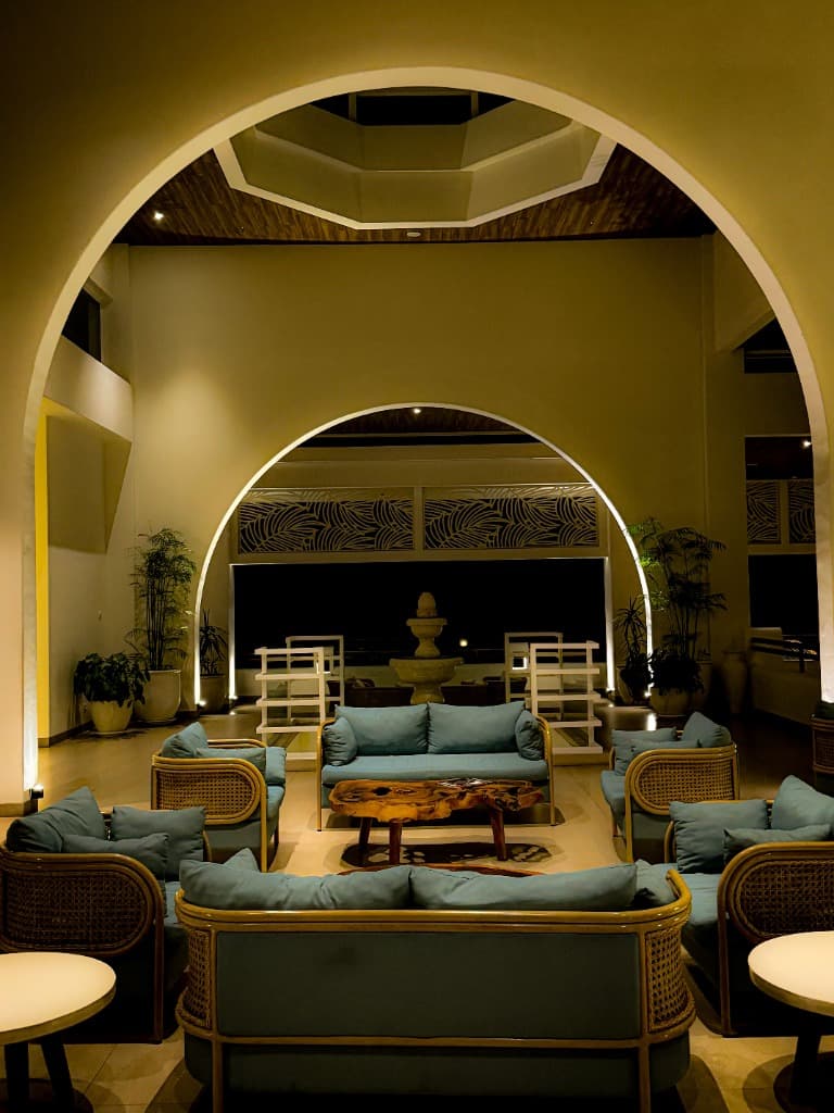 Grand architectural atrium lounge with illuminated arches and luxury teal banquettes